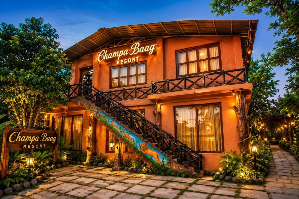 Champa Baag Resort Jagdalpur building with lush green garden, rustic architecture, warm evening lights, and peaceful nature ambience.